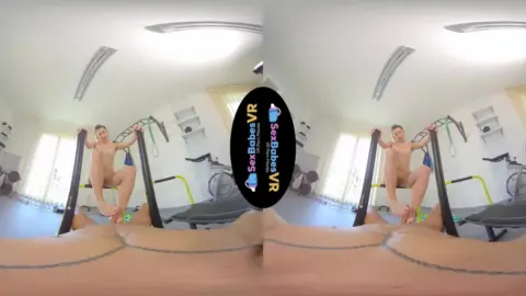 Brunette yoga girl stretches with green strap in home gym VR