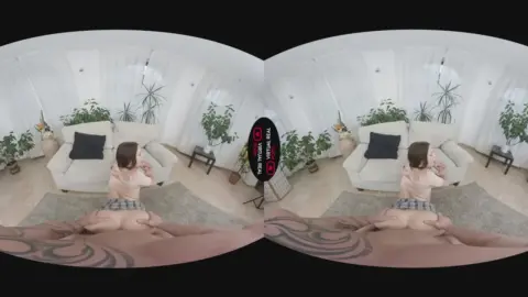 Slim brunette with tattoos spreads out on living room floor