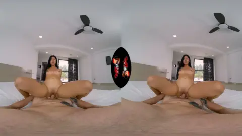 Asian girl with thigh tattoos spreads out on bed in well-lit room