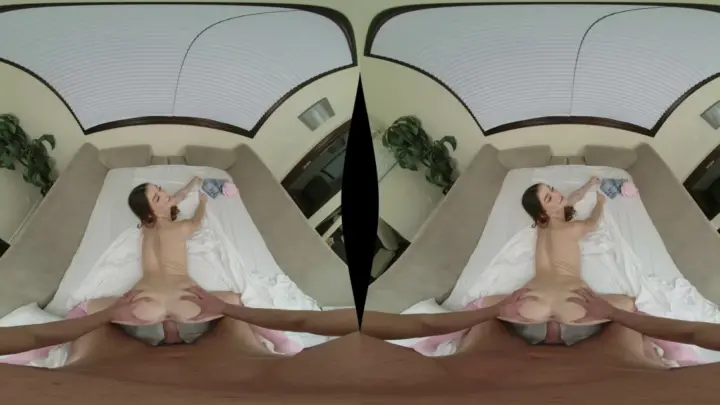 Brown-haired girl in pink stockings spreads on bed with natural light