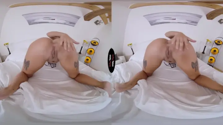 Blonde with thigh tattoos spreads out on white bed with yellow flowers