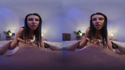 Black girl riding white guy in blue-lit bedroom