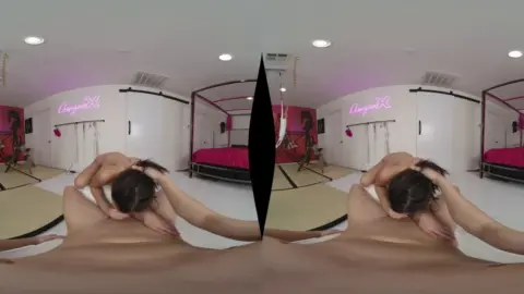Asian chick with tattoos jerking off on a pink bed under neon lights