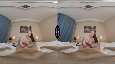 Slim brunette solo stretch in bed, hands on thighs, warm lighting